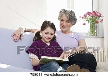A grandmother reading a book with her granddaughter View Large Photo Image Stock Image - A grandmother reading a book with her granddaughter. Fotosearch