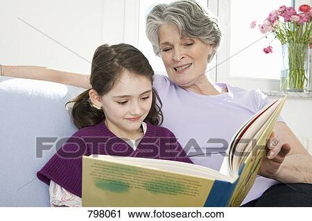 A grandmother reading a book with her granddaughter View Large Photo Image Stock Image - A grandmother reading a book with her granddaughter. Fotosearch