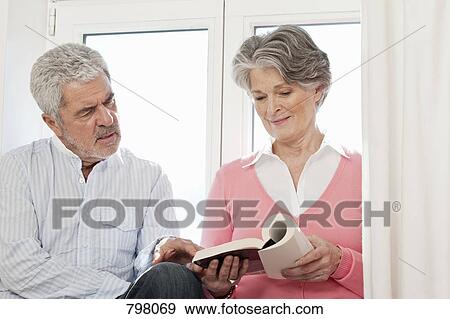 A senior couple looking at a book View Large Photo Image Stock Photo - A senior couple looking at a book. Fotosearch