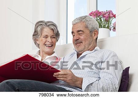 Picture - A senior couple looking through a book together. Fotosearch