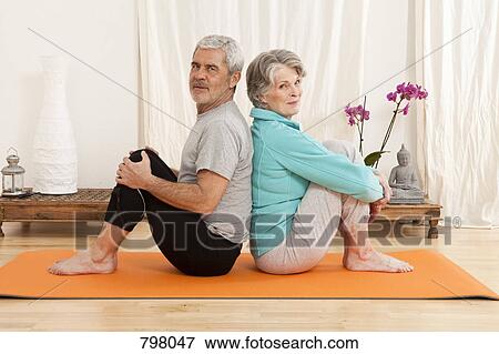 A senior man and a senior woman sitting back to back on an exercise mat View Large Photo Image Stock Photo - A senior man and a senior woman sitting back to back on an exercise mat. Fotosearch