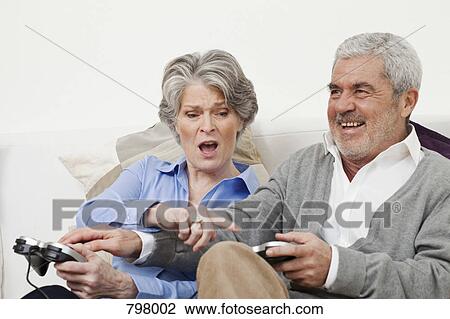 A senior man and senior woman playing a video game View Large Photo Image Stock Image - A senior man and senior woman playing a video game. Fotosearch