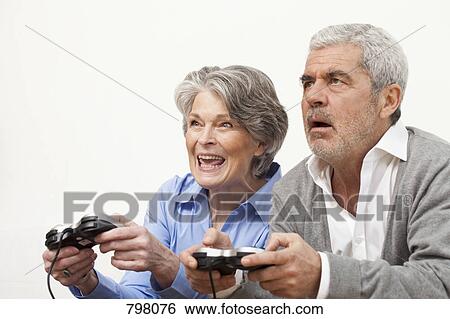 A senior man and senior woman playing a video game View Large Photo Image Stock Photograph - A senior man and senior woman playing a video game. Fotosearch
