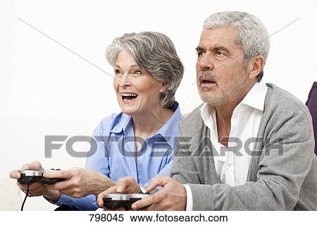A senior man and senior woman playing a video game View Large Photo Image Stock Photography - A senior man and senior woman playing a video game. Fotosearch
