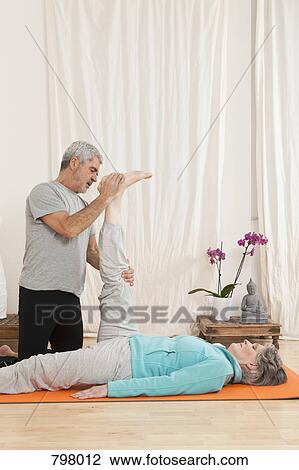 A senior man helping a senior woman stretching View Large Photo Image Stock Image - A senior man helping a senior woman stretching. Fotosearch