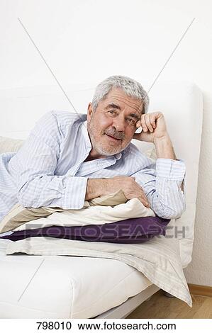 Stock Image - A senior man lying on a couch. Fotosearch