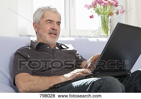 Stock Photo - A senior man using a laptop. Fotosearch