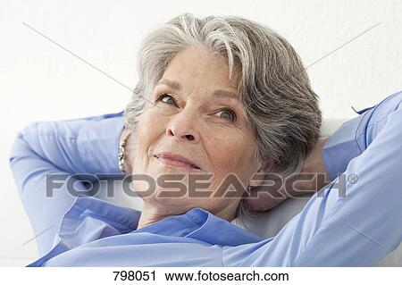 A senior woman relaxing with her hands behind her head View Large Photo Image Stock Image - A senior woman relaxing with her hands behind her head. Fotosearch