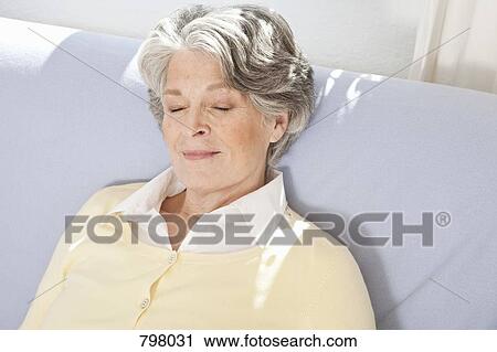 Stock Image - A senior woman sleeping on a couch. Fotosearch