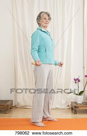 A senior woman stretching with a jump rope View Large Photo Image Stock Image - A senior woman stretching with a jump rope. Fotosearch