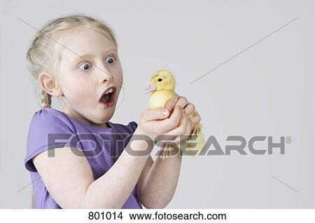 Picture - A girl holding a duckling. Fotosearch