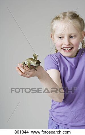 A girl holding a frog prince View Large Photo Image Picture - A girl holding a frog prince. Fotosearch