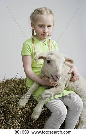 A girl with a white lamb, studio shot View Large Photo Image Stock Photo - A girl with a white lamb, studio shot. Fotosearch