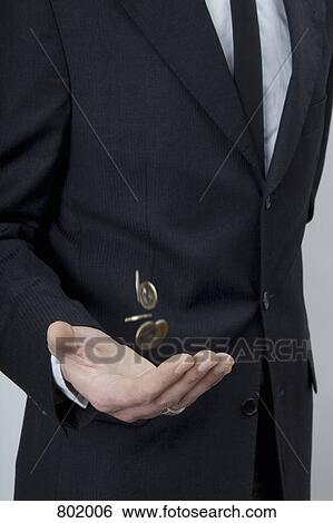 A man in a suit tossing change with his hand View Large Photo Image Stock Photograph - A man in a suit tossing change with his hand. Fotosearch