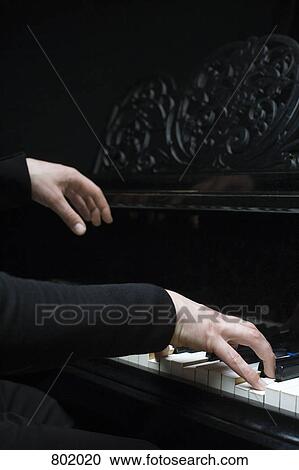 Stock Image - Human hands playing a piano. Fotosearch