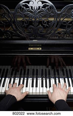 Stock Image - Human hands playing a piano. Fotosearch