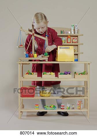 A girl playing in a children's wooden grocery store View Large Photo Image Picture - A girl playing in a children's wooden grocery store. Fotosearch