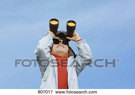 A young boy looking through binoculars View Large Photo Image Stock Photo - A young boy looking through binoculars. Fotosearch