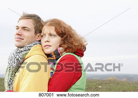 A young couple dressed in warm clothing embracing View Large Photo Image Stock Image - A young couple dressed in warm clothing embracing. Fotosearch
