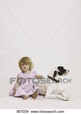 A young girl sitting next to a dog View Large Photo Image Picture - A young girl sitting next to a dog. Fotosearch