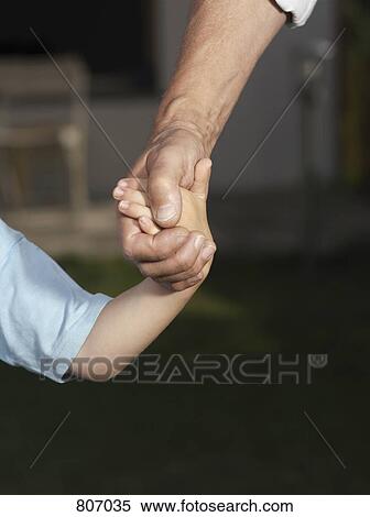 Detail of a child and a man holding hands View Large Photo Image Stock Photography - Detail of a child and a man holding hands. Fotosearch