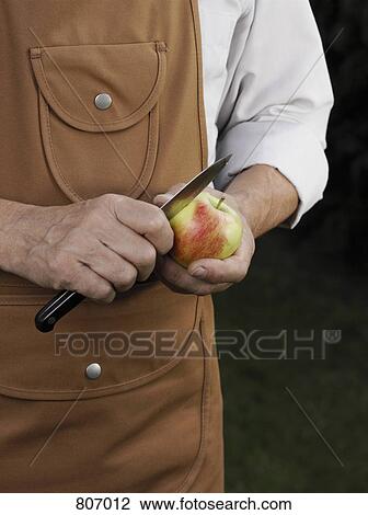 Stock Image - Detail of a man cutting an apple. Fotosearch