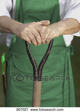 Midsection of a man holding a gardening tool View Large Photo Image Stock Photo - Midsection of a man holding a gardening tool. Fotosearch