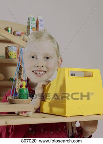 Stock Image - Portrait of a girl in a toy grocery store. Fotosearch
