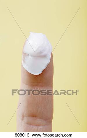 Stock Image - A human finger with lotion on it. Fotosearch