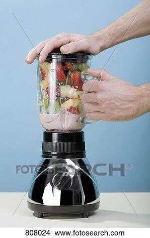 A human hand holding blender while it blends fruit View Large Photo Image Picture - A human hand holding blender while it blends fruit. Fotosearch