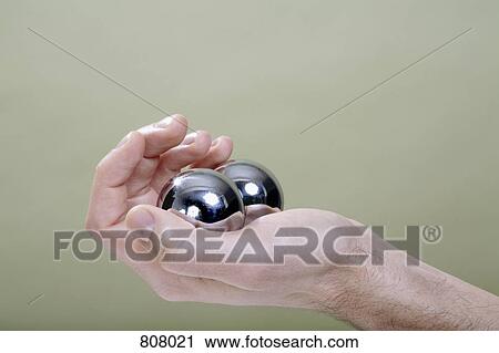 Stock Image - A human hand holding Chinese medicine balls. Fotosearch