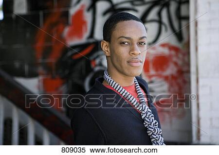 Portrait of a young man standing in front of graffiti on a wall View Large Photo Image Stock Photography - Portrait of a young man standing in front of graffiti on a wall. Fotosearch