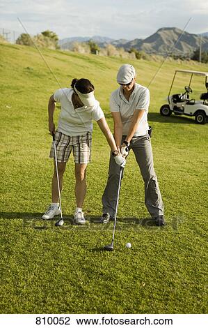 Stock Image - A golf instructor advising a golfer, Palm Springs, California, USA. Fotosearch