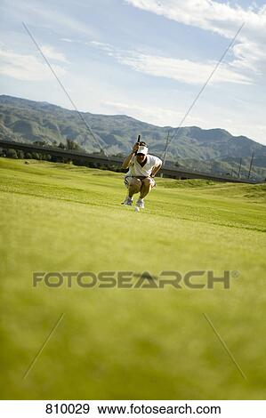 A golfer lining up a shot, Palm Springs, California, USA View Large Photo Image Stock Photo - A golfer lining up a shot, Palm Springs, California, USA. Fotosearch