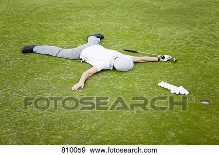 A golfer lying on a putting green behind an arrow of golf balls View Large Photo Image Stock Photo - A golfer lying on a putting green behind an arrow of golf balls. Fotosearch