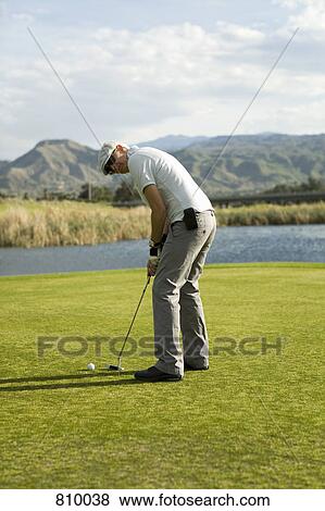 Stock Photo - A golfer putting, Palm Springs, California, USA. Fotosearch