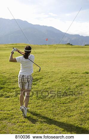 Stock Photograph - A woman playing golf, Palm Springs, California, USA. Fotosearch