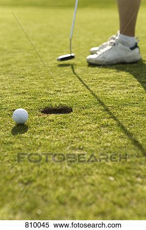 Detail of a golf ball next to a hole View Large Photo Image Stock Photography - Detail of a golf ball next to a hole. Fotosearch