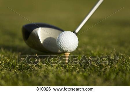 Stock Photograph - Detail of a golf club next to a golf ball on a tee. Fotosearch