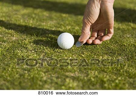 Detail of a golfer marking the ball's position with a coin View Large Photo Image Stock Photograph - Detail of a golfer marking the ball's position with a coin. Fotosearch
