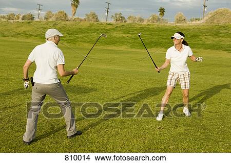 Picture - Two golfers sparring with golf clubs. Fotosearch