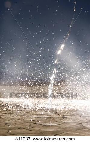 Stock Photo - Running water on dry cracked desert. Fotosearch