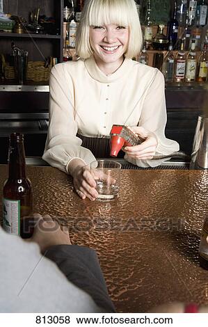A bartender making a drink at a bar View Large Photo Image Stock Photo - A bartender making a drink at a bar. Fotosearch