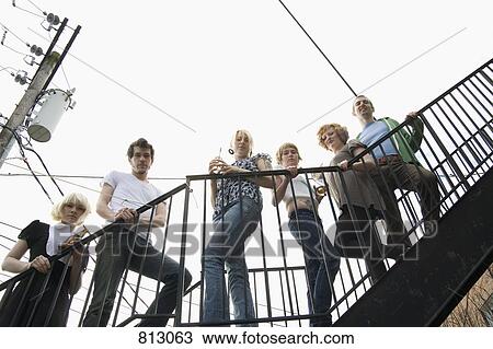 Stock Image - A group of friends standing on a stairway. Fotosearch