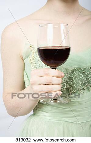 A woman wearing a vintage dress and holding a glass of red wine View Large Photo Image Stock Image - A woman wearing a vintage dress and holding a glass of red wine. Fotosearch
