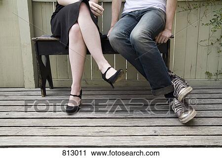 A young couple sitting on a patio bench View Large Photo Image Stock Image - A young couple sitting on a patio bench. Fotosearch
