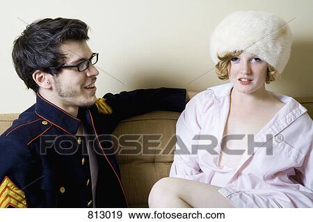 A young couple sitting on a sofa in costume View Large Photo Image Stock Photo - A young couple sitting on a sofa in costume. Fotosearch