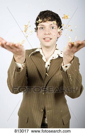 A young man tossing gold foil in the air View Large Photo Image Stock Photo - A young man tossing gold foil in the air. Fotosearch