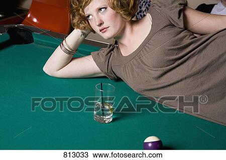 A young woman lying down across a pool table View Large Photo Image Stock Image - A young woman lying down across a pool table. Fotosearch