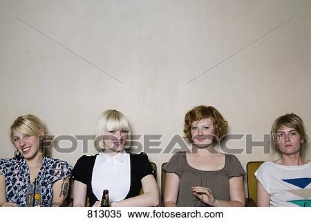 Four young woman sitting against a wall in a bar View Large Photo Image Stock Photography - Four young woman sitting against a wall in a bar . Fotosearch